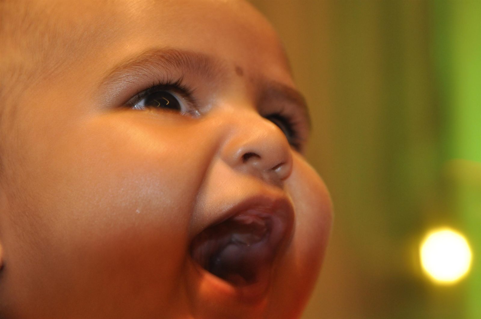 A baby gazing up in soft light