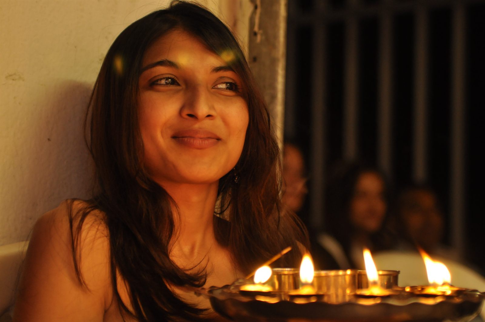 A woman smiling in warm candlelight