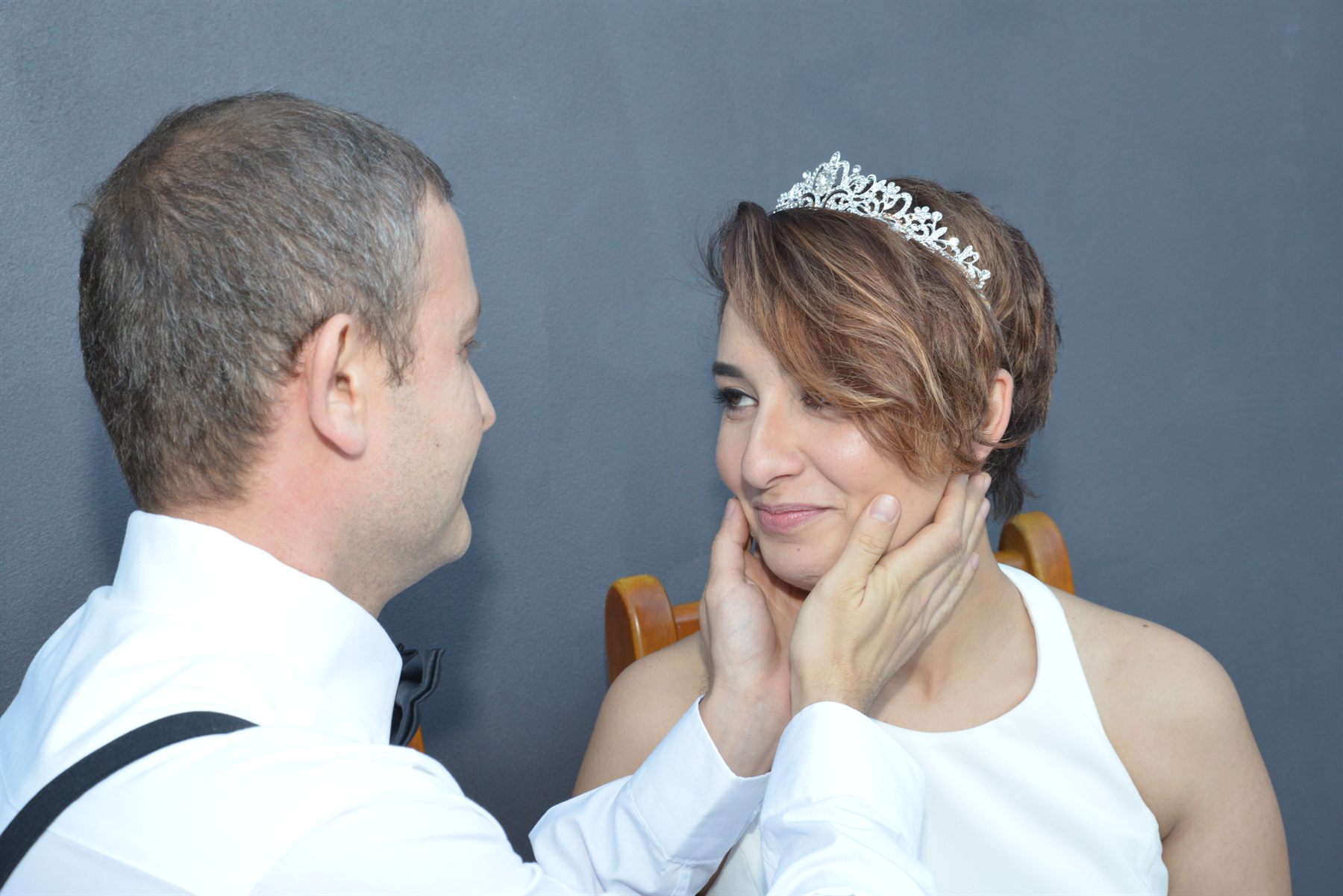 A bride resting her hand on her groom’s cheek, the two of them holding each other’s gaze