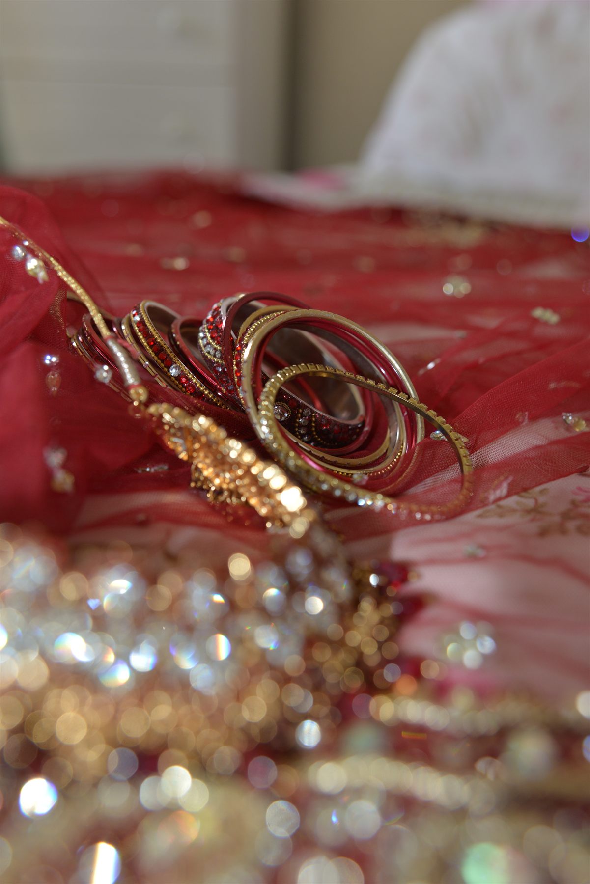 Gold bridal jewellery against a red embroidered sari