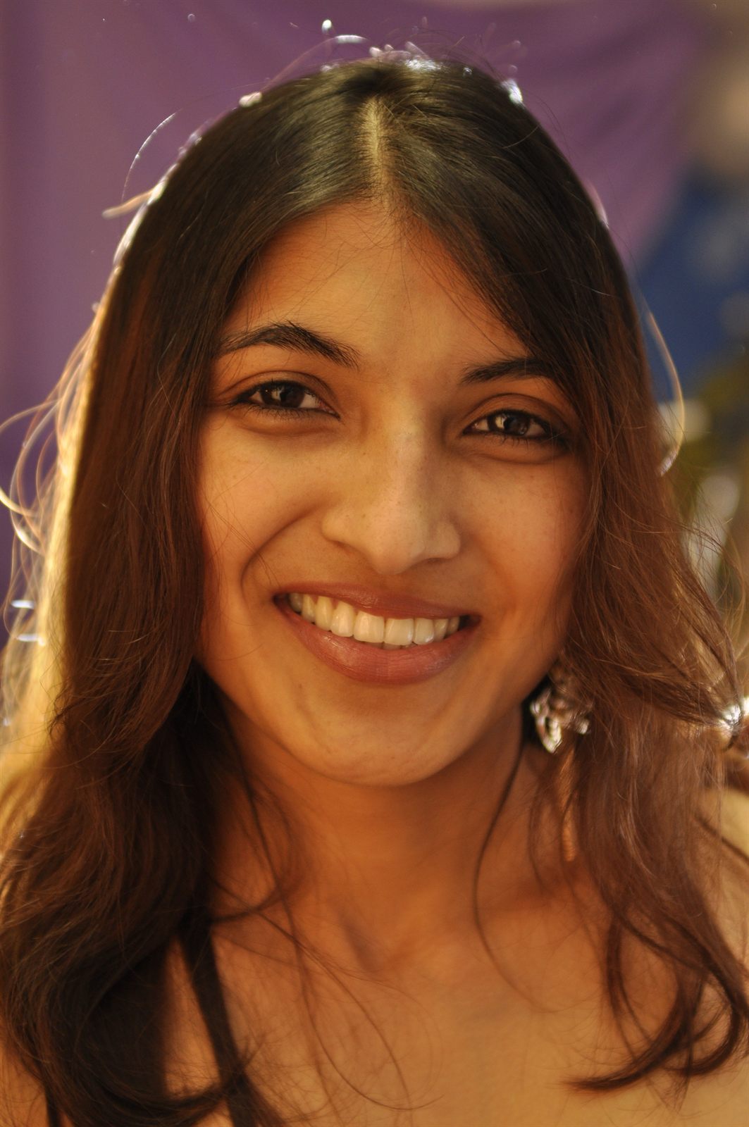 A young woman smiling warmly at a family celebration